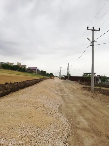Diyarbakır yol yapım şantiyesinde zemin kazısı tamamlanan bölgeye yol gövdesini oluşturmak üzere iş makineleri ve greyder yardımıyla alttemel malzemesi serilmesi ve tesviye edilmesi
