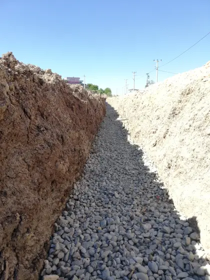Diyarbakır altyapı şantiyesinde drenaj hattı kazısı sonrasında borunun oturacağı tabana yataklama amacıyla filtre görevi görecek mıcır malzemesinin serilmesi