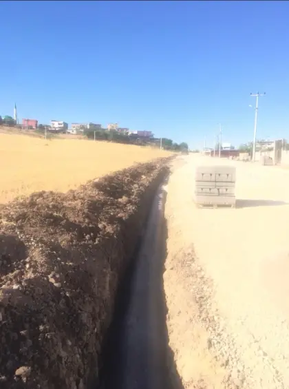 Diyarbakır altyapı şantiyesinde mıcır yataklaması üzerine döşenen drenaj borusunun, ince taneli malzemelerin boru deliklerini tıkamasını önlemek amacıyla geotekstil keçe ile sarılarak kapatılması