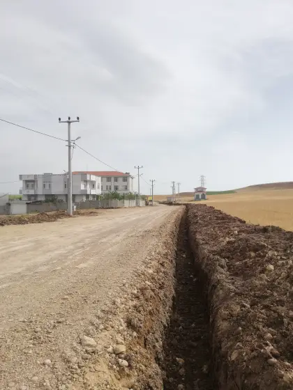 Diyarbakır altyapı şantiyesinde yağmur ve taban sularını tahliye edecek drenaj borusu hattı için yapılan kazı çalışması ve harita ekibinin kot kontrolü