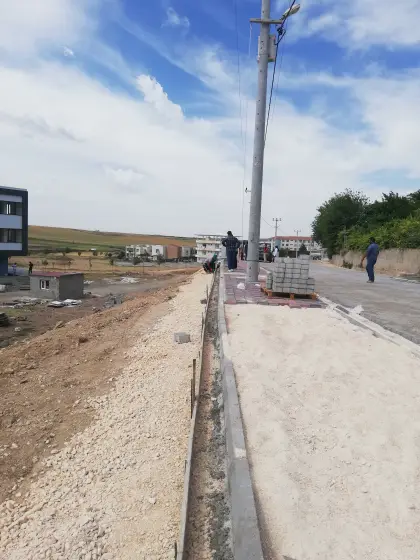 Diyarbakır kentsel çevre düzenleme projesinde yol kenarlarında beton bordür taşlarının dizilmesi ve kaldırım üzeri kilitli parke kaplama imalatının ustalar tarafından titizlikle yapılması