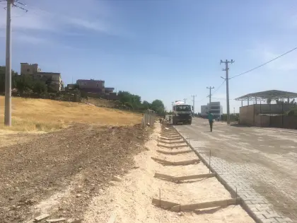 Diyarbakır üstyapı ve altyapı şantiyesinde tamamlanan kaldırım imalatının hemen yanına transmikser ile yağmur suyu tahliyesi için V kanal betonunun dökülmesi
