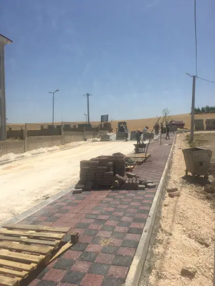 Diyarbakır üstyapı ve çevre düzenleme projesinde zemin hazırlığı biten cadde üzerinde kilitli parke taşı yol imalatının usta işçilikle döşenmesi