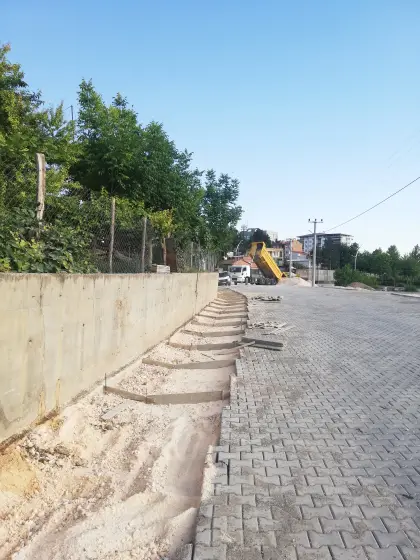 Diyarbakır altyapı şantiyesinde yüzey sularını tahliye edecek betonarme V kanal imalatı için yol kenarına çelik kalıpların kurulması ve teraziye alınması
