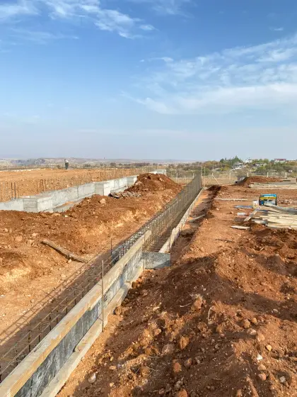 Diyarbakır Karacadağ OSB fabrika projesinde saha sınırlarını emniyete almak amacıyla inşaat firması tarafından gerçekleştirilen fabrika dışı istinat perdesi beton dökümü uygulaması