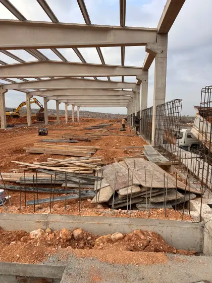 Diyarbakır Karacadağ OSB fabrika inşaatında dikilen prefabrik kolonların arasına yapısal mukavemet için perde duvar demir donatılarının montajlanması