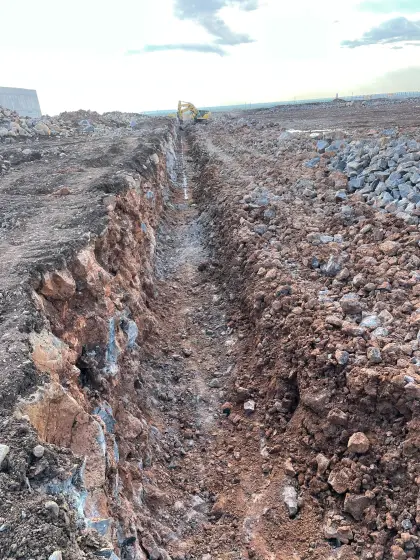 Diyarbakır Organize Sanayi Bölgesi fabrika projesinde şantiye sınır güvenliğini sağlayacak taş duvar imalatı öncesi ekskavatör ile yürütülen hat kazısı ve zemin hazırlığı