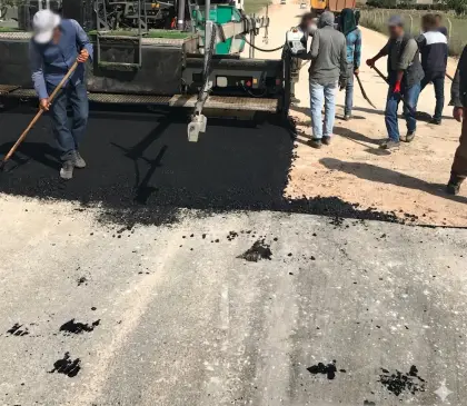 Diyarbakır Dicle yol projesinde sıcak asfaltın finişer serme makinesi ve kamyonlar eşliğinde yol gövdesine nizamlı ve pürüzsüz şekilde serilmesi