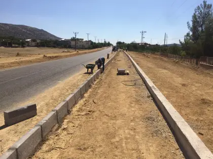 Diyarbakır kentsel düzenleme ve yol projesinde kaldırım imalatı için beton bordürlerin döşendiği ve sınır koruyucu perde betonunun atıldığı çalışma